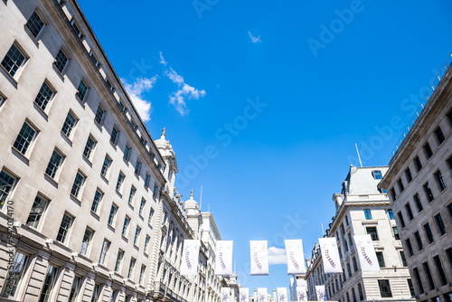 Looking up view on banners flags at Regent street road with Saint James's royal post office leading to Piccadilly circus in London, United Kingdom