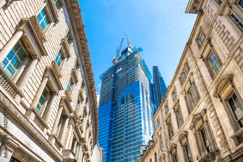 Looking up view at Threadneedle street road with old architecture, modern skyscraper office building in construction in City of London, United Kingdom photo