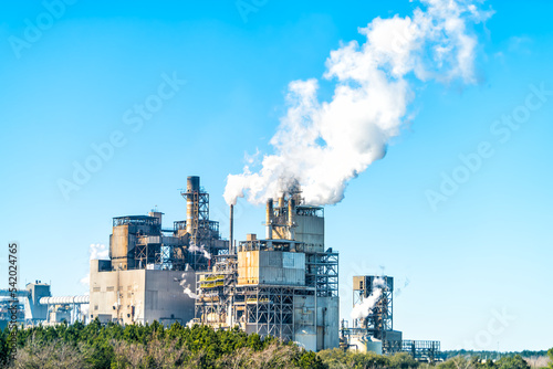 Valokuvatapetti Industrial paper mill factory plant with chimney smokestacks stacks emitting car
