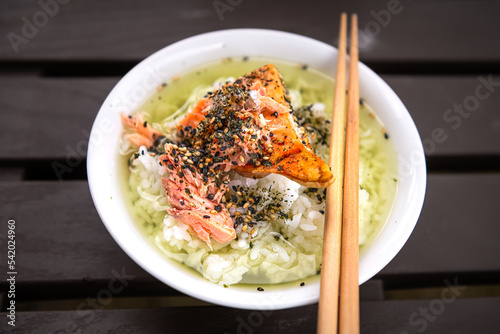 Macro closeup of traditional Japanese asian meal dish of ochazuke with grilled salmon, rice sesame seed furikake, nori in white bowl plate, chopsticks photo