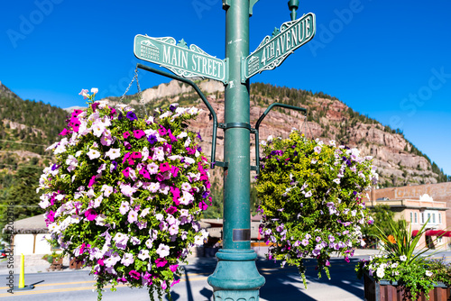 Fototapeta Naklejka Na Ścianę i Meble -  Ouray, Colorado small mining town in Rocky mountains with main street 4th avenue sign by calibrachoa flowers in hanging basket decoration in summer