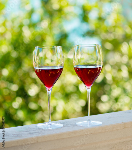 two glasses of red wine on the balcony