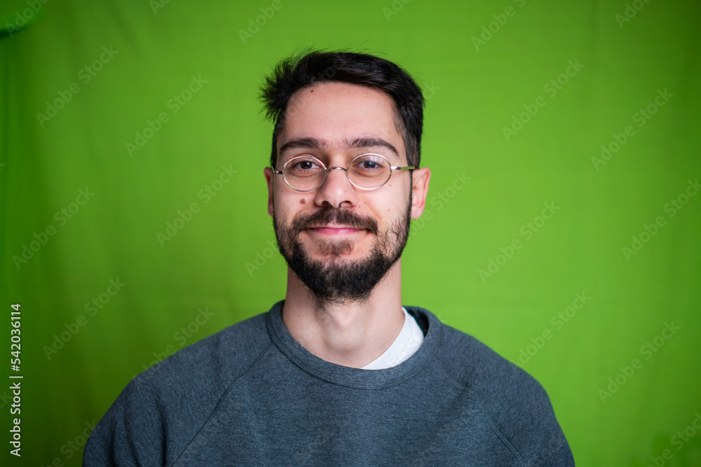 Young man with casual clothes, posing on green background Young man with casual clothes, posing on green background