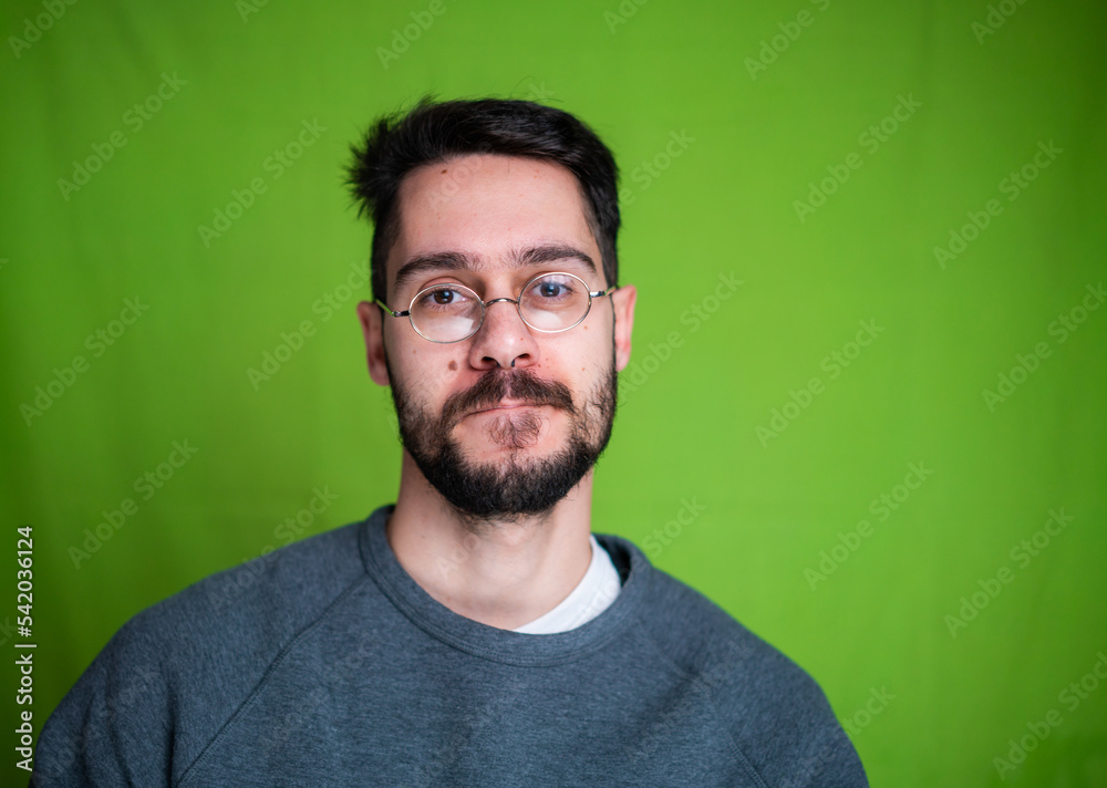 Fototapeta premium Young man with casual clothes, posing on green background