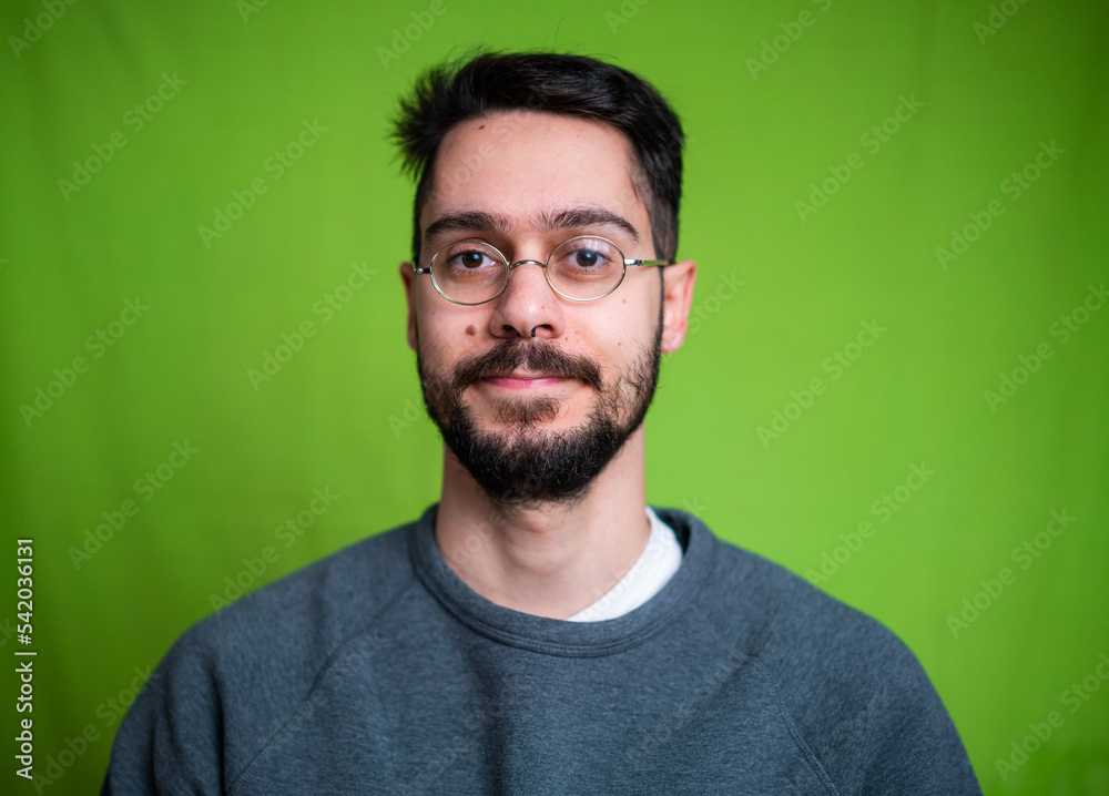 Young man with casual clothes, posing on green background Young man with casual clothes, posing on green background