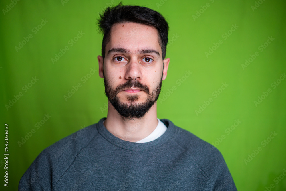 Young man with casual clothes, posing on green background Young man with casual clothes, posing on green background