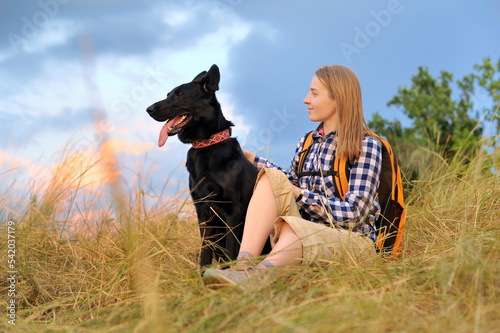 Woman with her dog against sky background