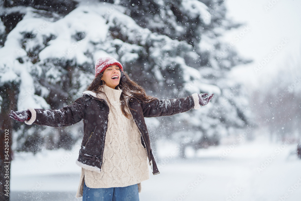 Beautiful woman standing among snowy trees and enjoying first snow. Holidays, rest, travel concept. Beautiful woman standing among snowy trees and enjoying first snow. Holidays, rest, travel concept.