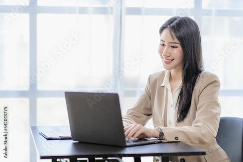 Asian businesswoman working in finance and calculator working with laptop computer with paper documents at office Technology market and financial concepts © ArLawKa