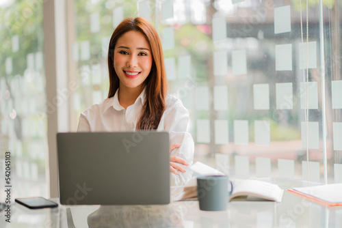 Asian businesswoman working in finance and calculator working with laptop computer with paper documents at office Technology market and financial concepts