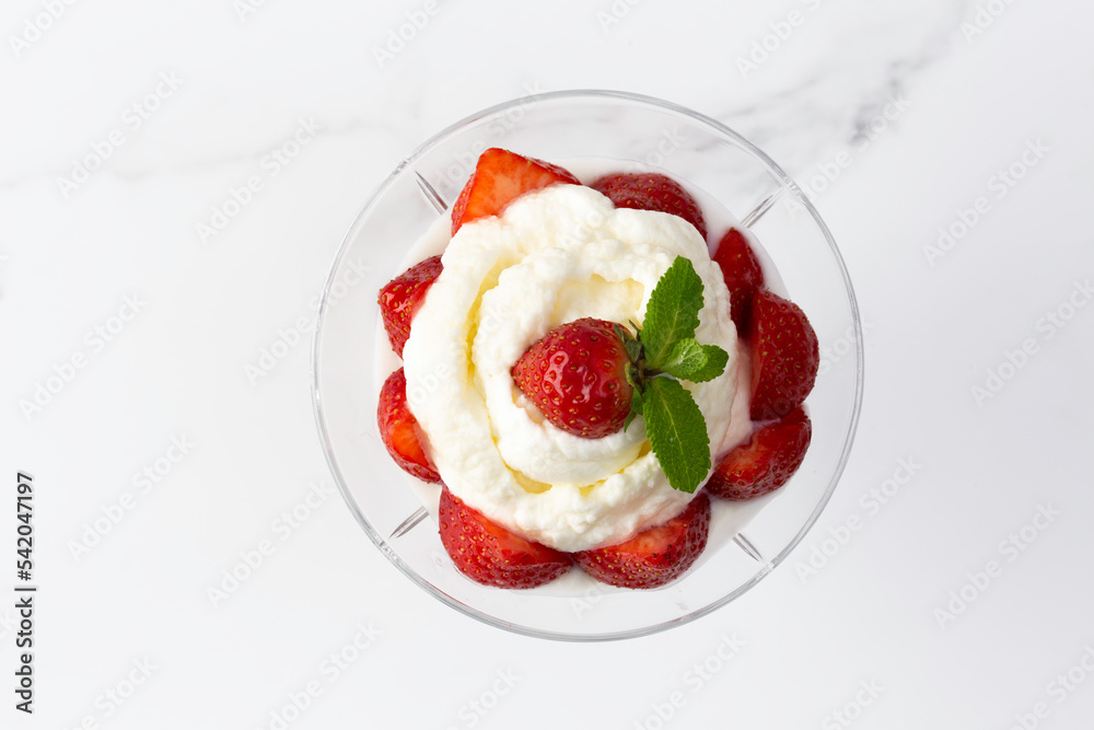 whipped cream with strawberries in a bowl on a light background whipped cream with strawberries in a bowl on a light background