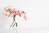 Beautiful flowers composition. Bouquet pink orchids in glass vase on white table. Pink phalaenopsis orchid flower white background. Concept Valentines Day, Happy Women's Day.