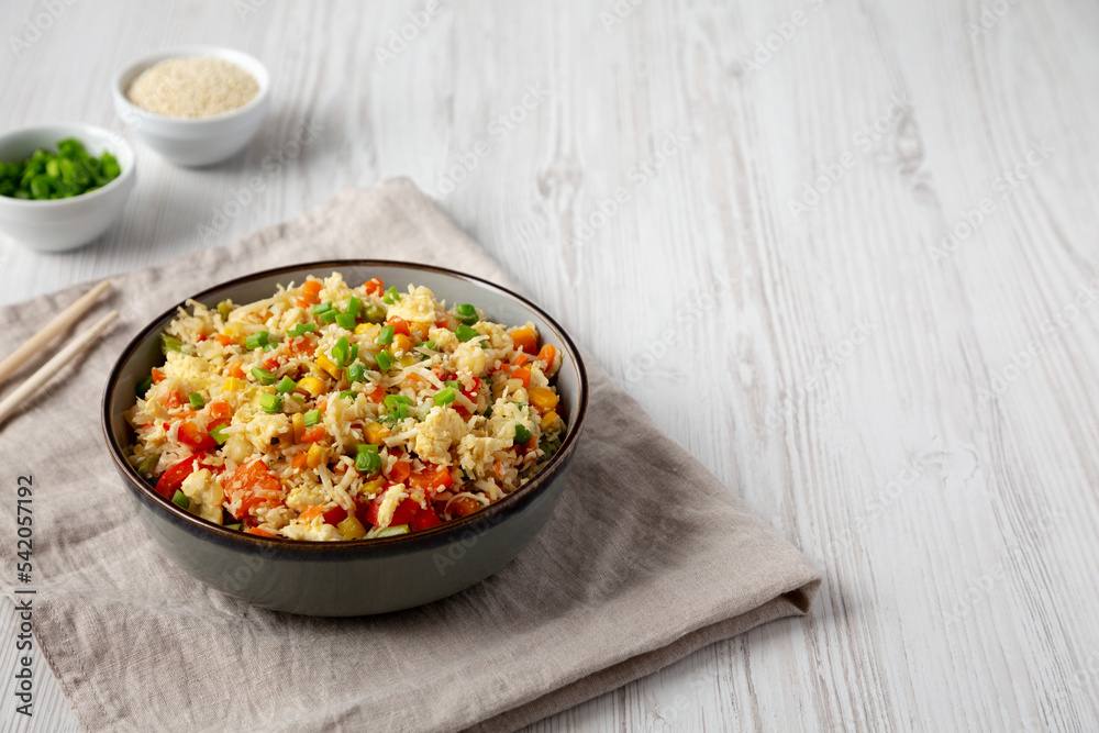 Homemade Cauliflower Fried Rice with Chives and Sesame Seeds in a Bowl, side view. Copy space. Homemade Cauliflower Fried Rice with Chives and Sesame Seeds in a Bowl, side view. Copy space.