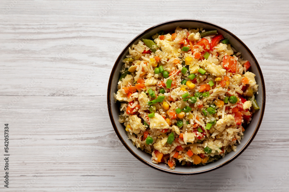 Homemade Cauliflower Fried Rice with Chives and Sesame Seeds in a Bowl, top view. Flat lay, overhead, from above. Copy space. Homemade Cauliflower Fried Rice with Chives and Sesame Seeds in a Bowl, top view. Flat lay, overhead, from above. Copy space.