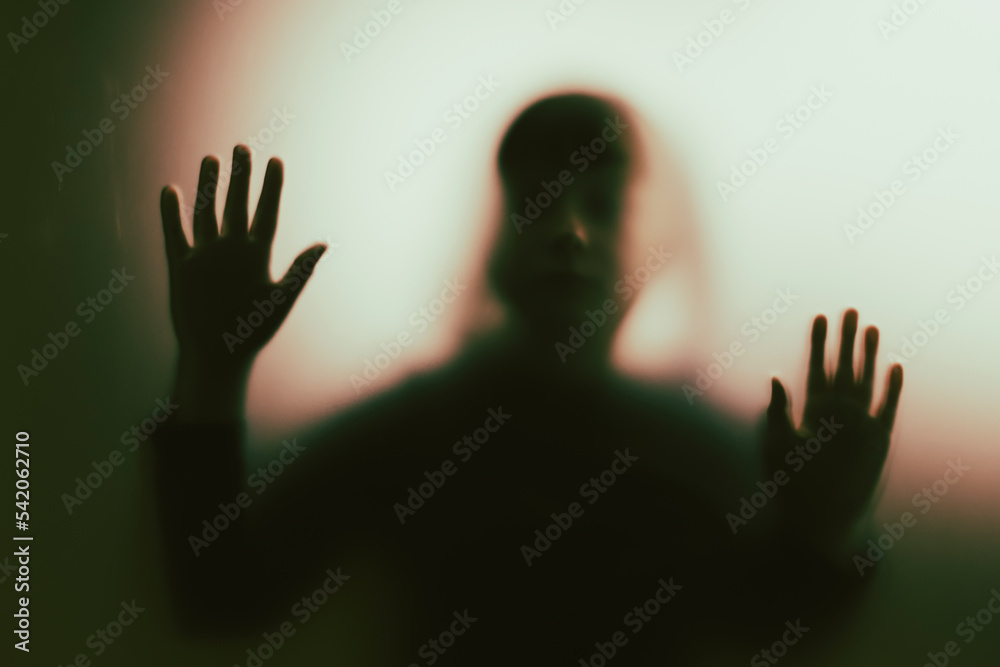 Shadowy figure, child behind glass - horror background Shadowy figure, child behind glass - horror background