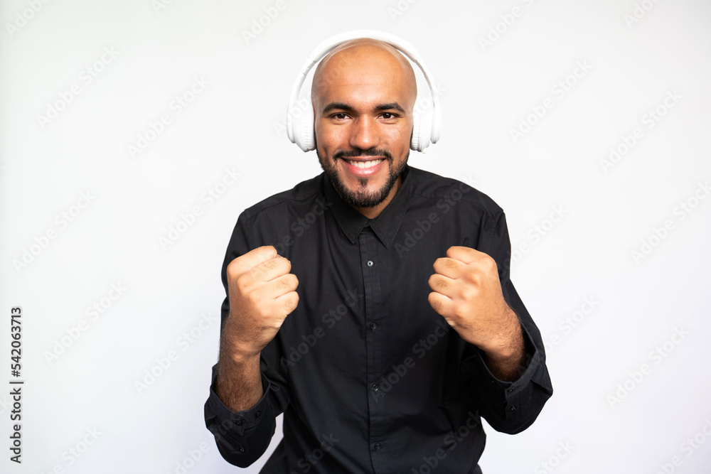 Portrait of serious young man in headphones looking away against white background. Young bearded businessman wearing black shirt looking upwards. Aspirations concept Portrait of serious young man in headphones looking away against white background. Young bearded businessman wearing black shirt looking upwards. Aspirations concept