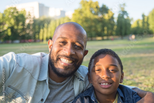 Tableau sur toile Smiling African American man and boy taking photo together