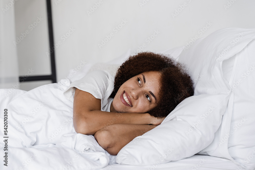 Nap day sleep of african girl lay on cozy bed at home. African american woman relaxing before awakening. Nap day sleep of african girl lay on cozy bed at home. African american woman relaxing before awakening.