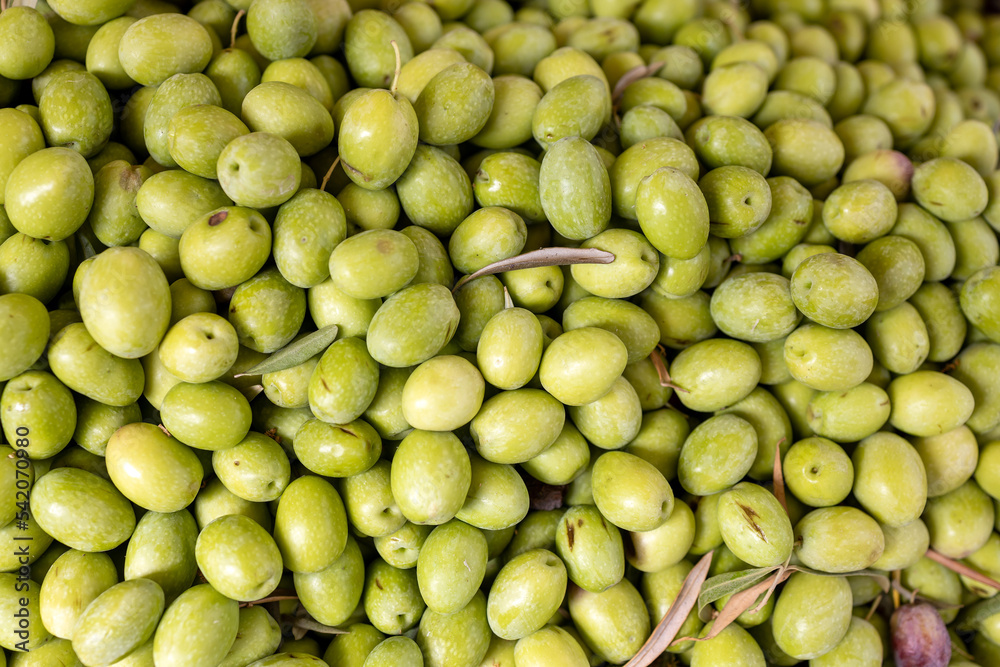 Green fresh olives in a plastic box for sale in the market Green fresh olives in a plastic box for sale in the market