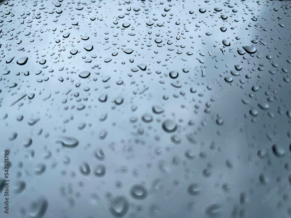 Rainwater drops running down the window glass Rainwater drops running down the window glass
