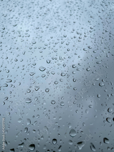 Rainwater drops running down the window glass