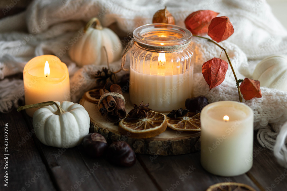 Autumn home composition with aromatic candle, dry citrus, cinnamon, anise. Aromatherapy on a grey fall morning, atmosphere of cosiness and relax. Wooden background close up Autumn home composition with aromatic candle, dry citrus, cinnamon, anise. Aromatherapy on a grey fall morning, atmosphere of cosiness and relax. Wooden background close up