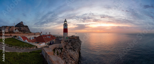 Europa Point Lighthouse with sea in background. Colorful Cloudy Sunrise Sky. Gibraltar, United Kingdom. Panorama