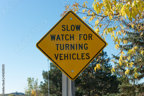 sign on bridge top: slow watch for turning vehicles
