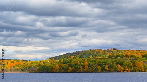 Fall Foliage along the Husson river with Olana State Historic Site at the top of the hill. photo