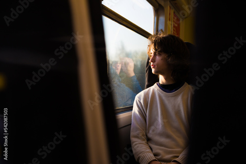 Young caucasian boy looking through a window train.