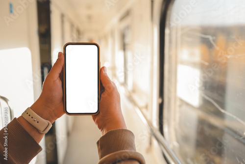 Fototapeta Naklejka Na Ścianę i Meble -  Phone in hands with an isolated screen on the background of the train cabin
