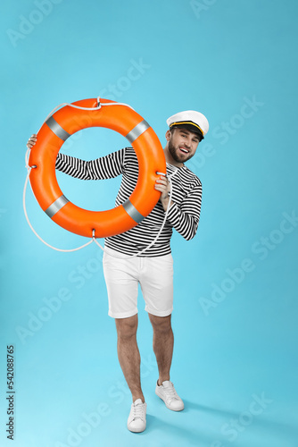 Sailor with ring buoy on light blue background