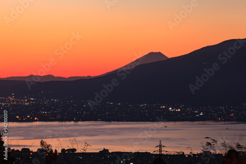 日本を代表する富士山の朝焼けは岡谷市からも見ることが出来ます 朝凪の諏訪湖もオレンジに染まります © noguchibiyousitu