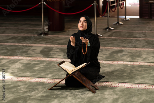 Young Beautiful Muslim Woman Praying in Mosque photo