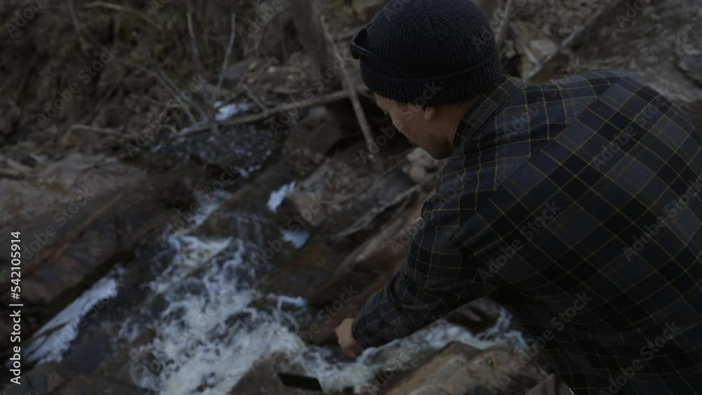 Man attempts to take photo of waterfall in nature and drops phone into the water - slow motion Man attempts to take photo of waterfall in nature and drops phone into the water - slow motion