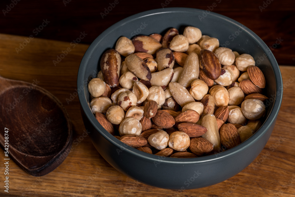 Mixture of hazelnuts, almonds and Brazil nuts, poured into a green ceramic bowl. A mix of nuts of different kinds. Nut mixture. A source of healthy fats, amino acids and microelements. Mixture of hazelnuts, almonds and Brazil nuts, poured into a green ceramic bowl. A mix of nuts of different kinds. Nut mixture. A source of healthy fats, amino acids and microelements.