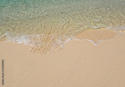 Clear ocean waves on a clean sandy beach.