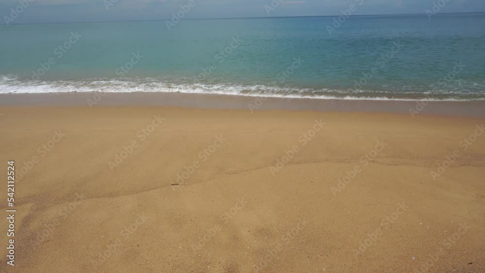 viewing angle of white quartz sand grains with sea waves and the cloudy sky in the background viewing angle of white quartz sand grains with sea waves and the cloudy sky in the background