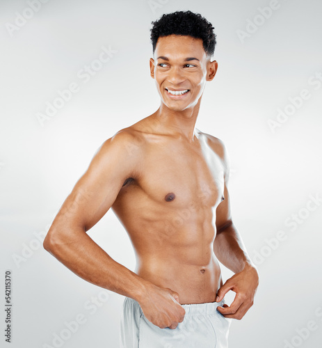 Skincare, cleaning and man in towel after shower in studio for wellness, beauty and grooming against white background. Skin, bodycare and bathroom hygiene with guy model confident, muscular and happy