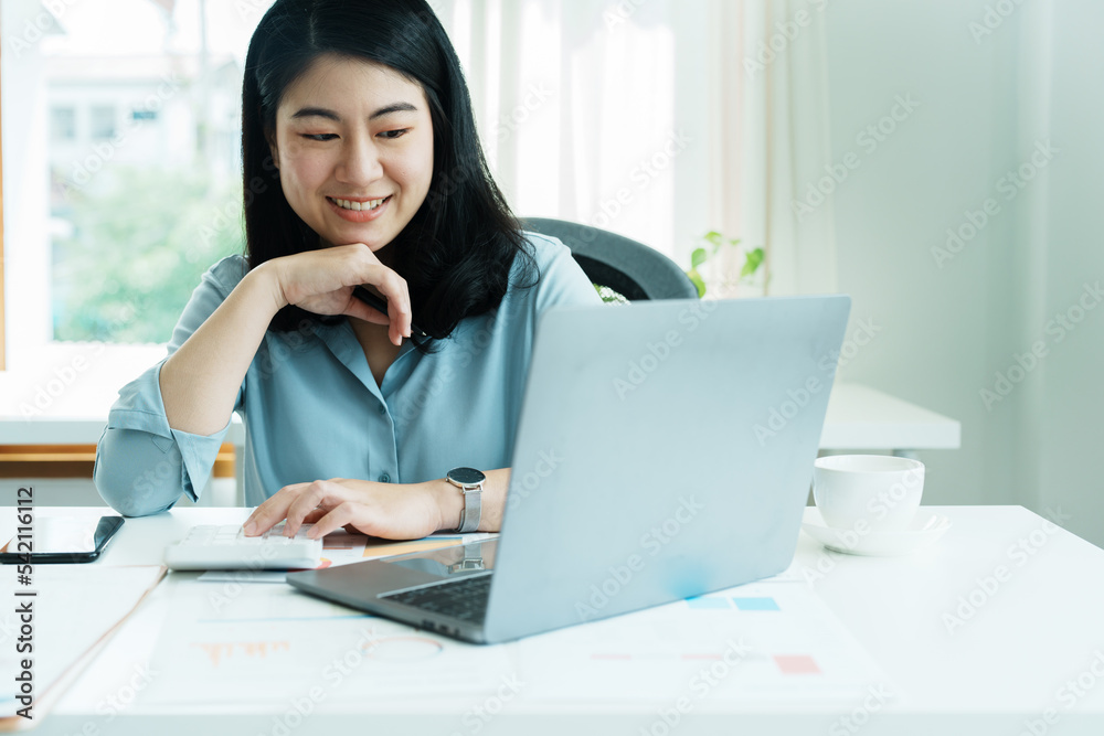 financial, Planning, Marketing and Accounting, portrait of Asian employee checking financial statements using documents and calculators and computer at work financial, Planning, Marketing and Accounting, portrait of Asian employee checking financial statements using documents and calculators and computer at work