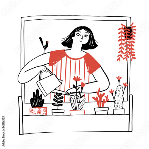 The attractive woman watering flowers in the apartment.