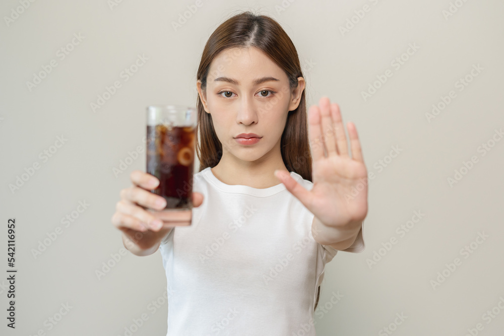 Diet, Dieting. Attractive asian young woman, girl push out cold cola, refuse carbonated soft drink soda, sparkling water by her hand. Health care, healthy lifestyle concept, avoid limits sweet sugar. Diet, Dieting. Attractive asian young woman, girl push out cold cola, refuse carbonated soft drink soda, sparkling water by her hand. Health care, healthy lifestyle concept, avoid limits sweet sugar.