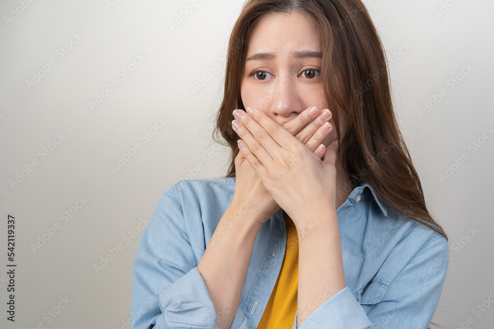 Portrait of pretty brunette hair, disgust smell bad breath strong asian young woman, girl covering, close her mouth with hand, expression face disgusting, dislike odor. Isolated on white background. Portrait of pretty brunette hair, disgust smell bad breath strong asian young woman, girl covering, close her mouth with hand, expression face disgusting, dislike odor. Isolated on white background.