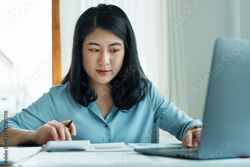 financial, Planning, Marketing and Accounting, portrait of Asian employee checking financial statements using documents and calculators and computer at work