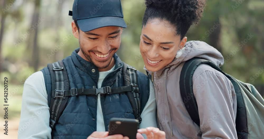 Hiking, smartphone and travel couple with location search, online travel guide or nature journey planning together in a forest on 5g network. Backpack trekking people using phone mobile app in woods