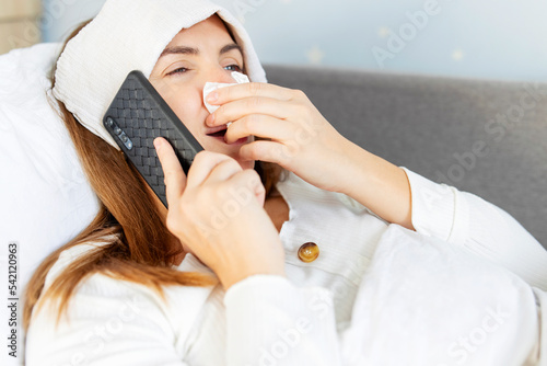 Sick woman with a runny nose calling the doctor for help and advice