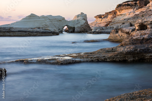 rocky coast with arch at sunset