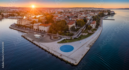 Zadar, Croatia - Aerial panoramic view of the old town of Zadar by the Adriatic sea with The Greeting to the Sun monument, Zadar skyline, sea organ, blue sky and golden rising sun on a summer morning
