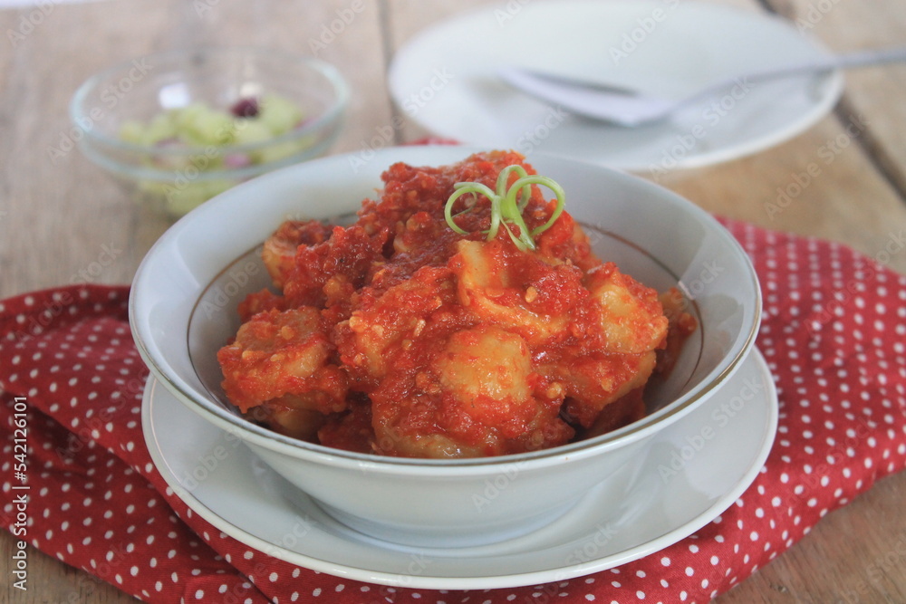 Sambal fried meatballs in a white bowl on a table covered with red polka dot cloth
Sambal fried meatballs in a white bowl on a table covered with red polka dot cloth