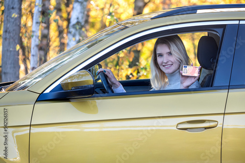 Young woman with a driving license document.